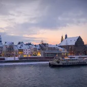 Sunset over Maastricht's docks, with a boat on the water.