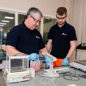 Two men in black and safety goggles working on Cemex’s Prime admixtures in its lab 