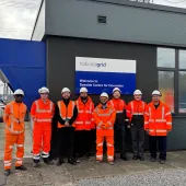 The Hyperion Robotics and National Grid teams, all in orange PPE, stand outside the Deeside Centre for Innovation, National Grid’s advanced testing facility in North Wales.