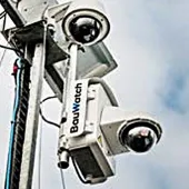 A close-up view looking up at two solar powered CCTV cameras mounted on a pole.