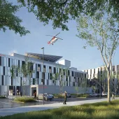 A red helicopter flies over the new Caen University Hospital, which features 110,000 m² of healthcare space built using lower-carbon concrete. Photo Credit: ©CHU de Caen Normandie