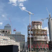 High rise buildings under construction with a tower crane and 1 Canada Wharf in the background