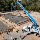 A concrete pump places concrete during construction of foundations