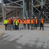 A group of people in yellow and orange PPE from Material Evolution, CRH, CRH Ventures & Tarmac at the Mevo A1 Production Facility in Llay, Wales