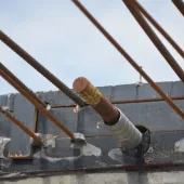 Metal rebar protruding from the end of a concrete beam.