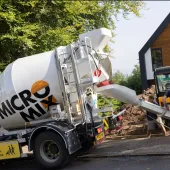 Two men unload concrete from one of Micromix’s agile trucks, which can deliver concrete loads from 0.5 to 4 m³, now with added convenience via online ordering.