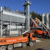 An orange tipper truck and orange cement mixer wait by the new iMIX plant in Essex is MCT Italy’s first UK ready-mix installation, built for high-volume output and flexibility.