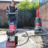 A man with beard using one of Trelawny’s new VoltMax range, which includes a grinder, scarifier and stripper – all powered by 82V lithium-ion batteries, prepares a surface for construction work