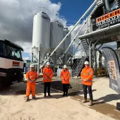 Four people in orange PPE stand in front of Biker Group’s new Stockton-on-Tees concrete plant, which represents a £1.5 million investment in the region.