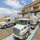 Two US trucks load up with materials at Eco Material Technologies, which supplies supplementary cementitious materials, critical for reducing embodied carbon in concrete.
