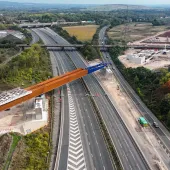 An aerial view of The HS2 viaduct East Deck being slid into place over the M6, supported by four pairs of reinforced concrete piers.