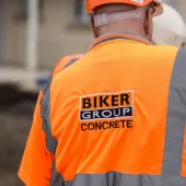 A construction worker in Biker Group branded orange PPE and hard hat