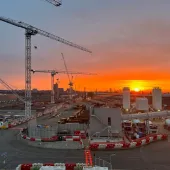 Sunrise over the construction of Old Oak Common Station in London, one of several HS2 sites supplied by Holcim UK, with a tower silhouetted against a setting sun