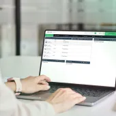 A close up of someone's hands working on a laptop
