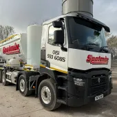 A white screed truck with red decals