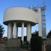 A view of a round concrete water tower and access tower
