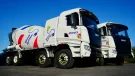 Two of Cemex's new electric trucks, which are designed for urban use, offering up to a 100% reduction in CO₂ emissions when powered by renewable energy and operate at significantly lower noise levels than traditional diesel-powered vehicles.