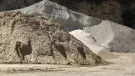 Two piles of aggregate on a quarry floor