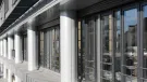 A glass fronted office with concrete columns.