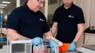 Two men in black and safety goggles working on Cemex’s Prime admixtures in its lab 