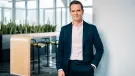 Dr Dominik von Achten, in dark suit and open neck shirt, standing in an empty office, has been elected the new president of GCCA, is chairman of the managing board at Heidelberg Materials