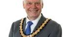 A photo of Paul Gandy, president, CIOB, wearing a grey suit, white shirt, blue tie and ceremonial chain.