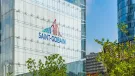 The blue and red Saint-Gobain logo on the side of a glass paneled, high-rise building.