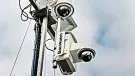 A close-up view looking up at two solar powered CCTV cameras mounted on a pole.