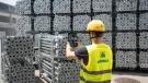 A man in Doka branded PPE uses an AI device to count formwork elements