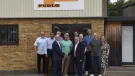 Malcolm Thornton and Scott Wilson (shaking hands) pictured with the PUDLO team outside their office following the deal to buy the company.