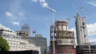 High rise buildings under construction with a tower crane and 1 Canada Wharf in the background