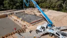 A concrete pump places concrete during construction of foundations