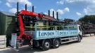A blue London Lintels liveried truck with red loader crane mounted at the rear in London Lintels yard. London Lintels, now part of the Milbank Group, distributes concrete and steel lintels to customers across London and the South.