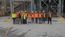 A group of people in yellow and orange PPE from Material Evolution, CRH, CRH Ventures & Tarmac at the Mevo A1 Production Facility in Llay, Wales