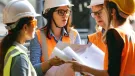 In the warm glow of the afternoon sun, a team of construction professionals gather closely, passionately engaged in a project discussion. Clad in safety helmets and high-visibility vests, they exchange ideas over blueprints, their collaboration a testament to the intricate planning that underpins successful infrastructure projects. Each individual's focused expression underscores the importance of each decision in the grand tapestry of urban development.