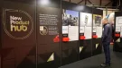 A man stands right of frame looking at entries to the UK Concrete Show's New Product Hub, which are displayed on a large, floor standing board.