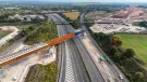 An aerial view of The HS2 viaduct East Deck being slid into place over the M6, supported by four pairs of reinforced concrete piers.