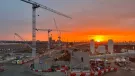 Sunrise over the construction of Old Oak Common Station in London, one of several HS2 sites supplied by Holcim UK, with a tower silhouetted against a setting sun
