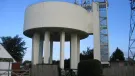 A view of a round concrete water tower and access tower